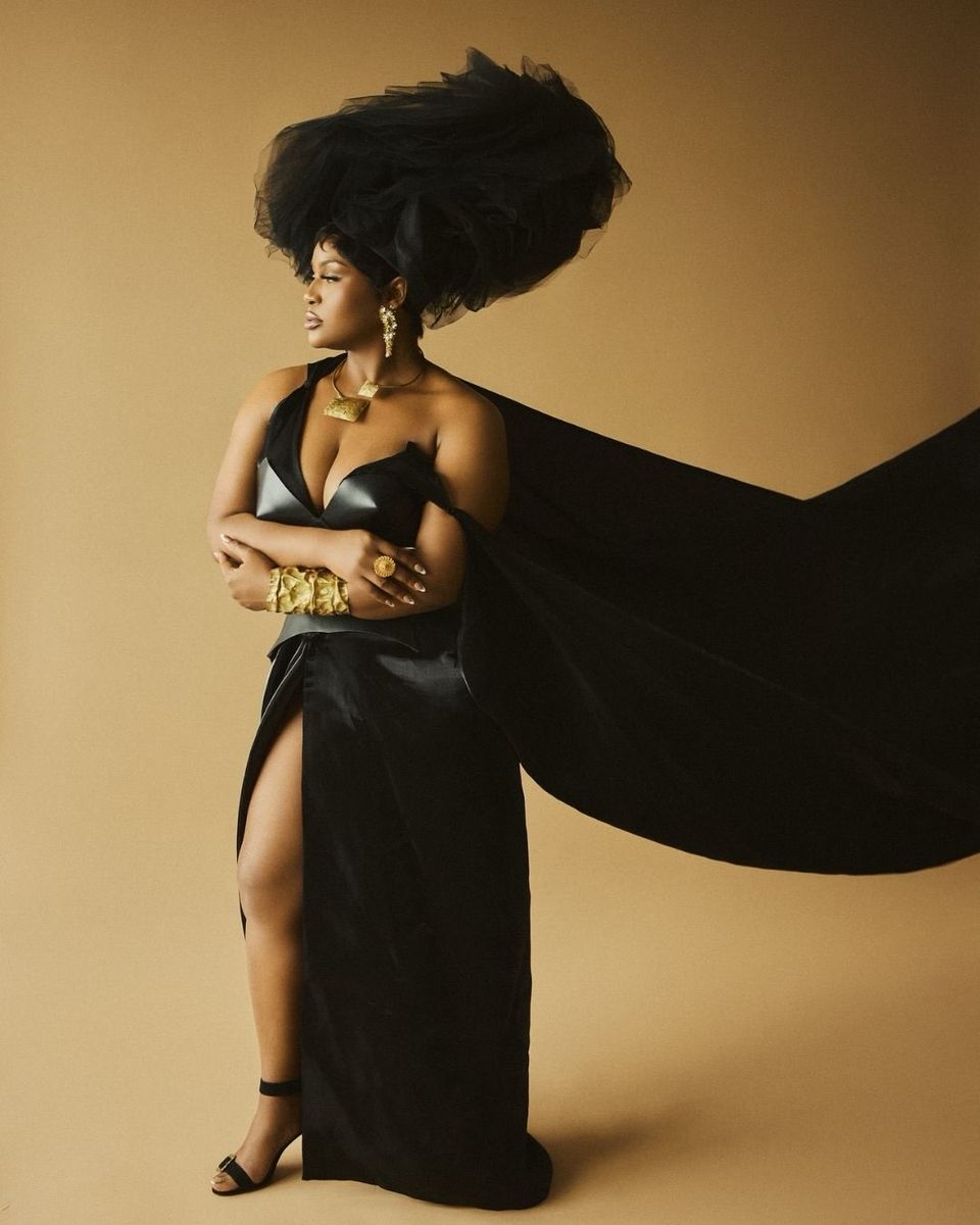 Black satin gown with a long cape on ochre